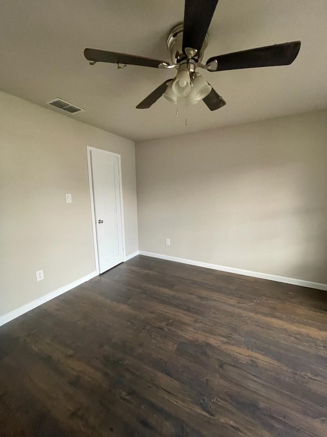 empty room with dark hardwood / wood-style flooring and ceiling fan