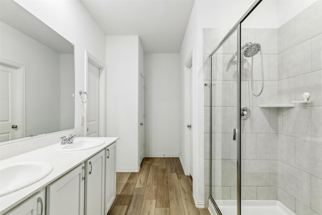 bathroom featuring hardwood / wood-style floors, vanity, and an enclosed shower