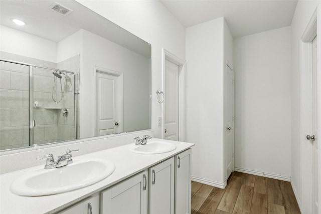 bathroom featuring hardwood / wood-style flooring, vanity, and an enclosed shower