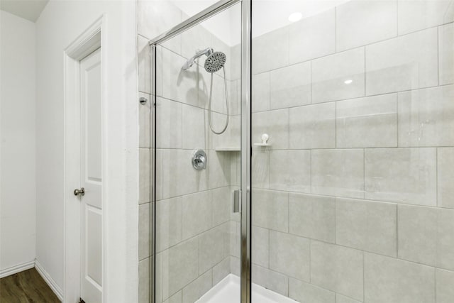 bathroom featuring a shower with door and wood-type flooring