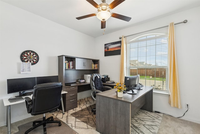 carpeted office with a wealth of natural light and ceiling fan