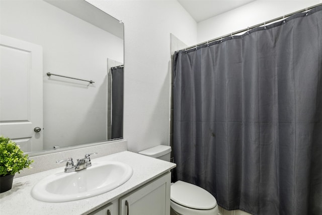 bathroom featuring curtained shower, vanity, and toilet