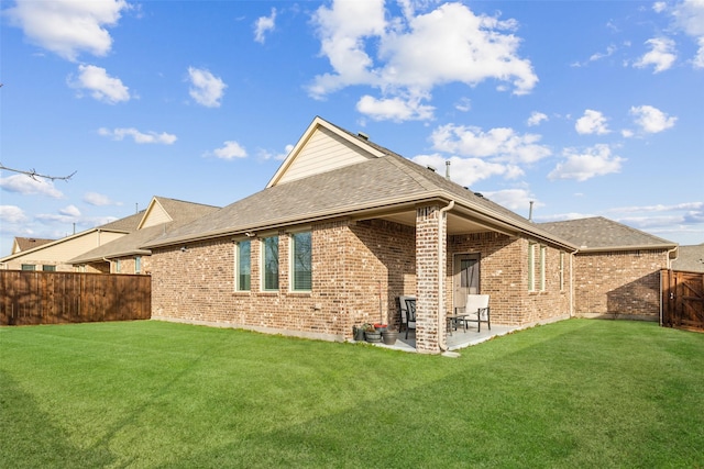 back of house with a lawn and a patio area