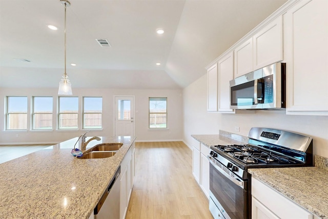 789 Merry Summit Rd, Lavon, TX 75166 - kitchen featuring appliances with stainless steel finishes, light stone counters, a sink, light wood-style flooring, and white cabinetry