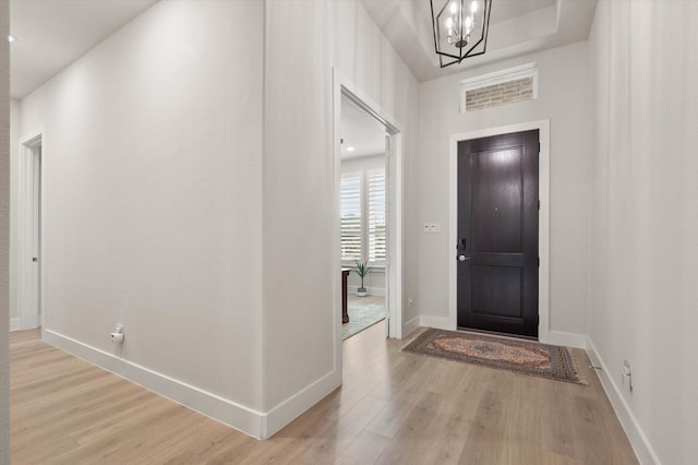 entrance foyer featuring a notable chandelier and light hardwood / wood-style flooring