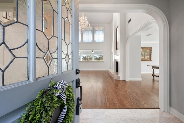 foyer featuring crown molding, a chandelier, and light wood-type flooring