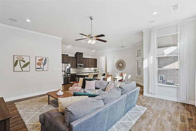 living room featuring ceiling fan, light wood-type flooring, and ornamental molding