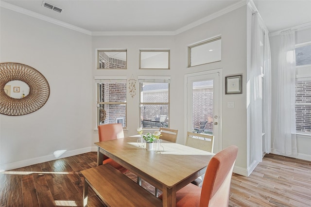 dining space featuring light hardwood / wood-style floors and crown molding