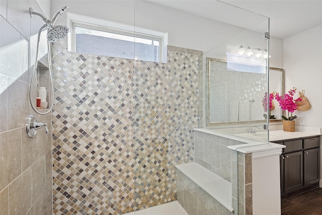 bathroom featuring wood-type flooring, vanity, and a tile shower