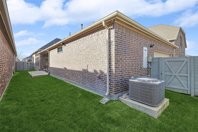 view of side of home with a yard and central AC unit