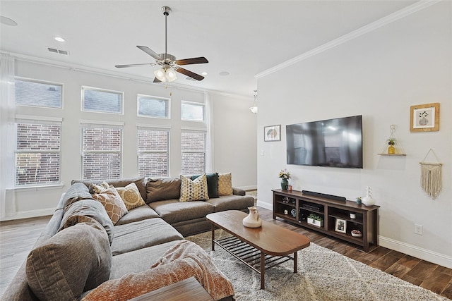 living room featuring dark hardwood / wood-style floors, ceiling fan, crown molding, and a wealth of natural light