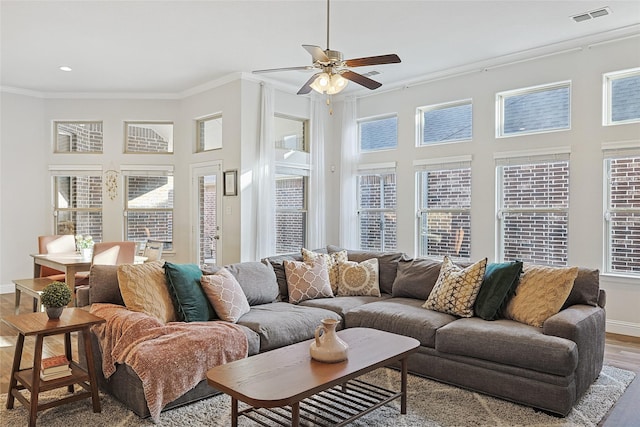 living room featuring ceiling fan, ornamental molding, and light hardwood / wood-style flooring