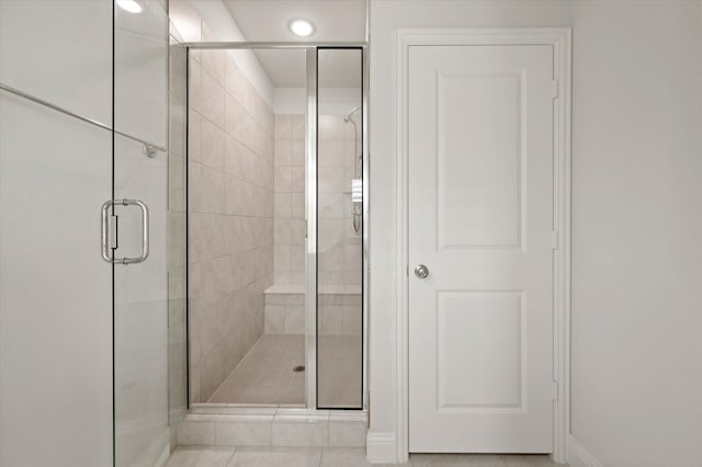 bathroom with tile patterned flooring and a shower with door