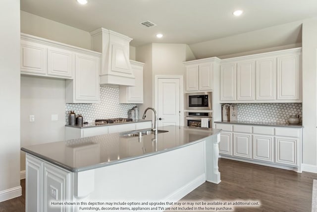 kitchen featuring sink, a kitchen island with sink, white cabinets, custom exhaust hood, and stainless steel gas stovetop