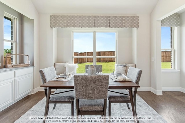 dining area with vaulted ceiling, plenty of natural light, and dark wood-type flooring