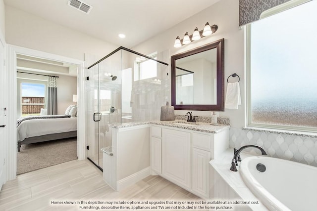 bathroom with vanity and shower with separate bathtub