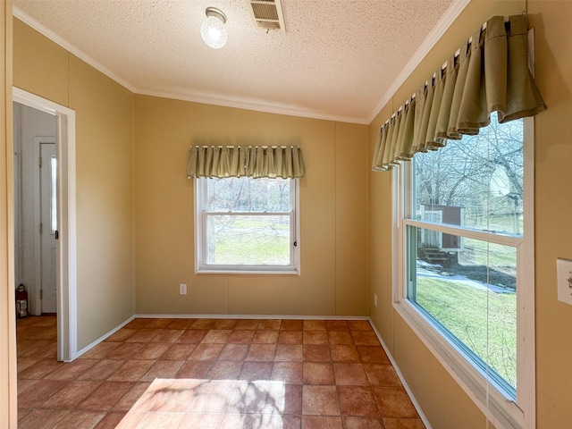 spare room featuring crown molding and a textured ceiling