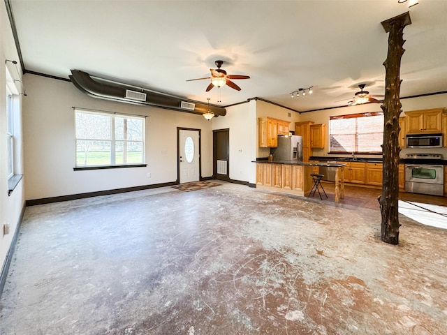 kitchen featuring stainless steel appliances, ornamental molding, plenty of natural light, and a kitchen bar