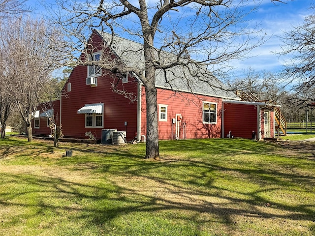 back of property featuring cooling unit and a yard