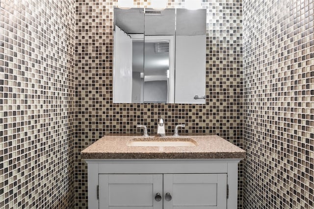 bathroom featuring decorative backsplash, vanity, and tile walls