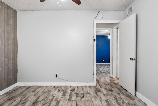 spare room featuring ceiling fan, wood-type flooring, and a textured ceiling