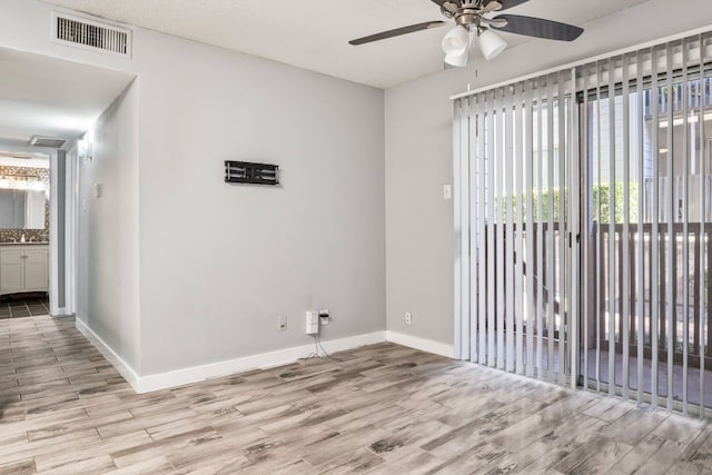 empty room with light wood-type flooring and ceiling fan