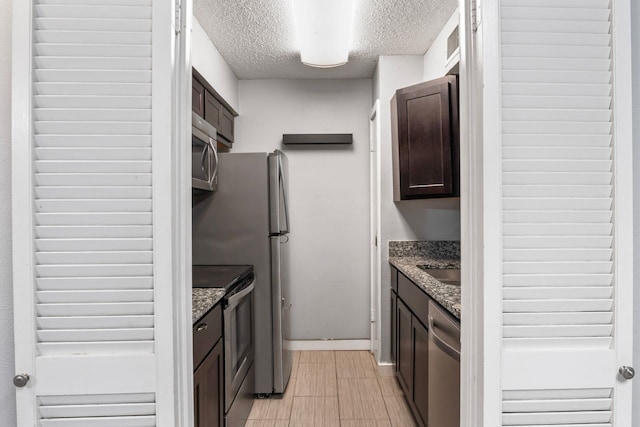 kitchen with stone counters, appliances with stainless steel finishes, and dark brown cabinetry