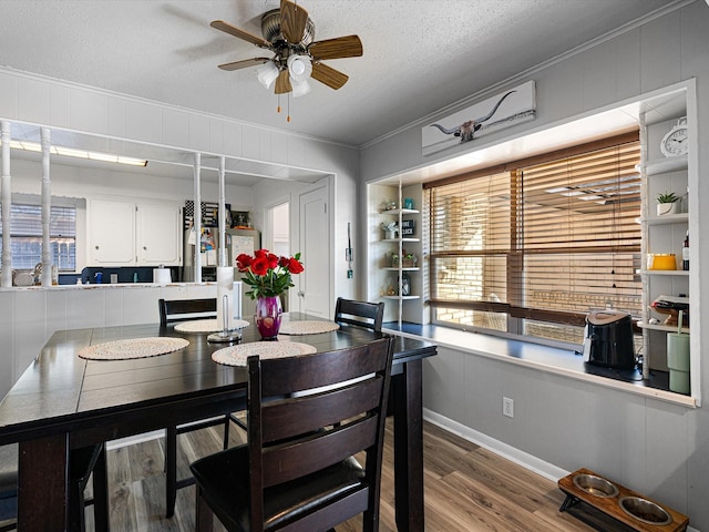 dining space with ceiling fan, built in features, crown molding, hardwood / wood-style floors, and a textured ceiling