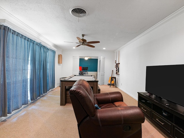 carpeted living room featuring a textured ceiling, ceiling fan, and crown molding