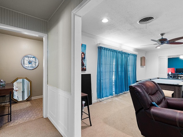 office space featuring carpet flooring, ceiling fan, crown molding, and a textured ceiling