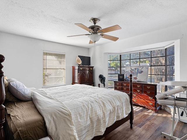 bedroom featuring ceiling fan, dark hardwood / wood-style floors, and a textured ceiling