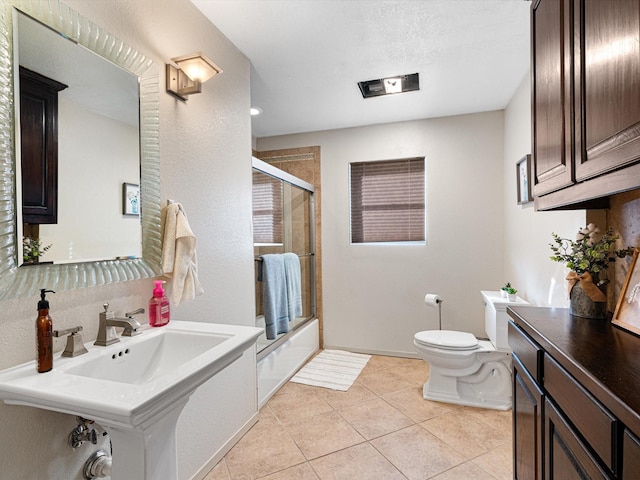 bathroom featuring toilet, tile patterned flooring, and combined bath / shower with glass door