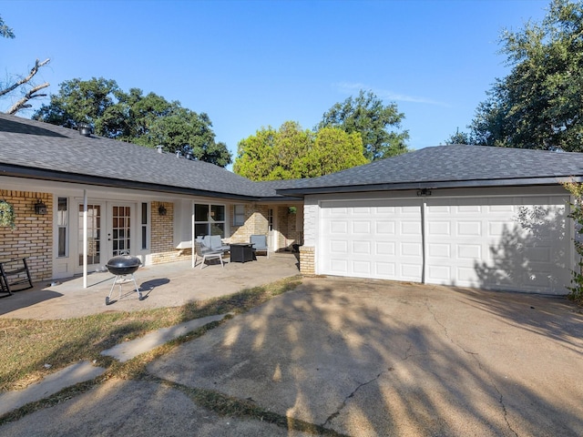 view of front of house featuring a patio area, french doors, and a garage