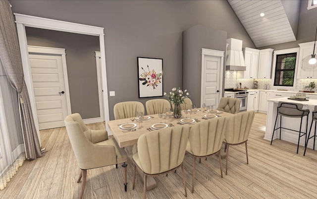 dining space with light hardwood / wood-style flooring and lofted ceiling