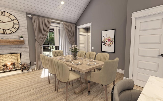 dining space with a fireplace, vaulted ceiling, and light wood-type flooring