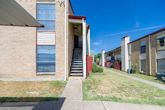 exterior space with a lawn and central AC