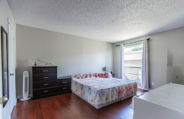 bedroom with a textured ceiling and dark wood-type flooring