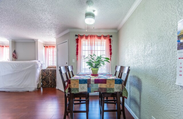 dining room with a textured ceiling, dark hardwood / wood-style flooring, and crown molding