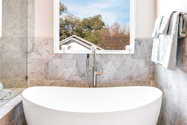 bathroom featuring a bathtub, tile walls, and sink