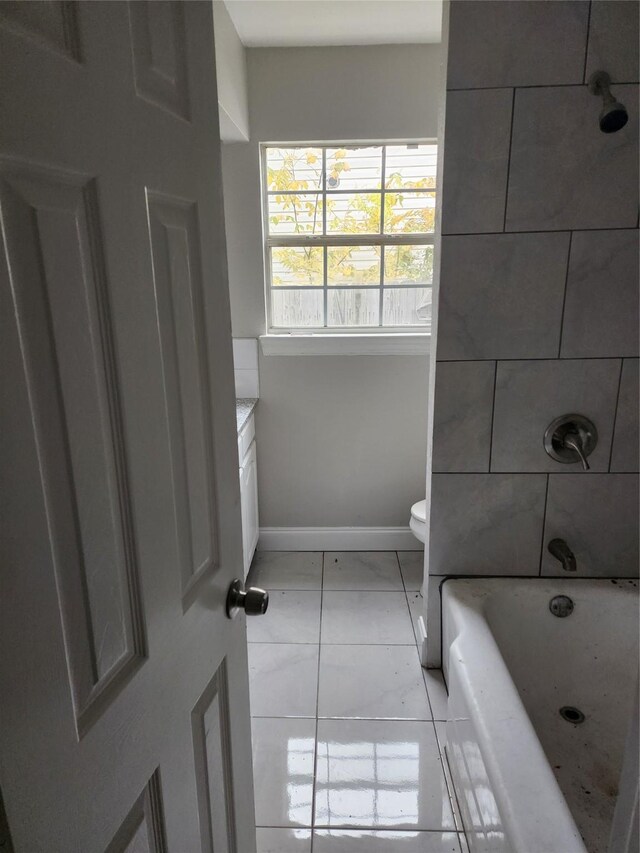 full bathroom featuring tile patterned floors, vanity, tiled shower / bath combo, and toilet