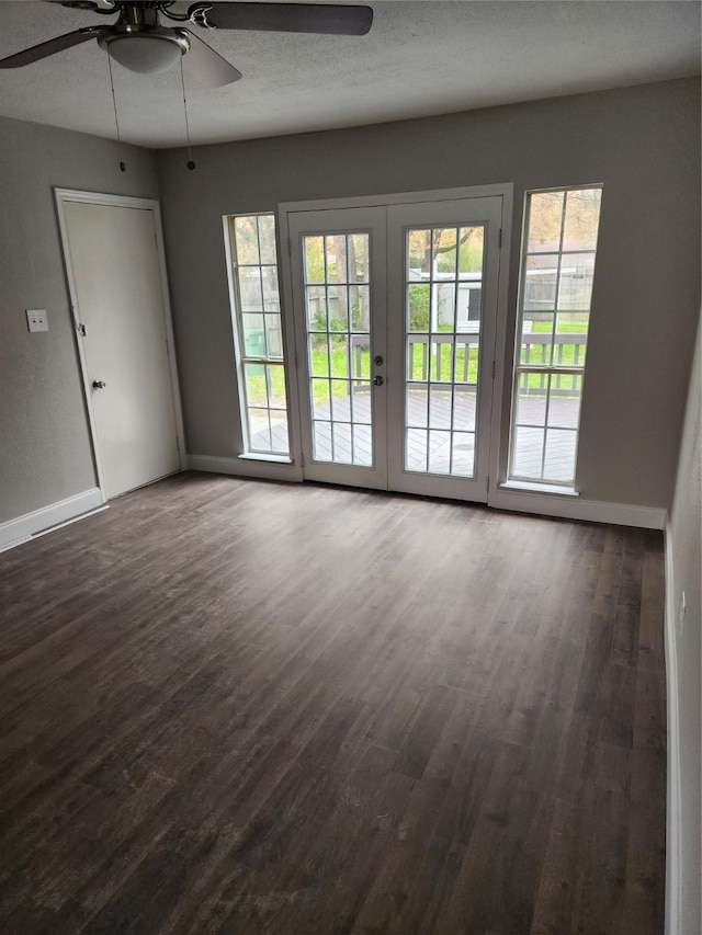 unfurnished room featuring ceiling fan, dark wood-type flooring, a textured ceiling, and french doors