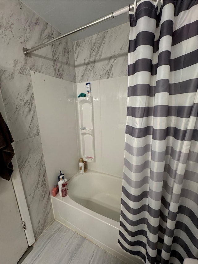 bathroom featuring wood-type flooring, tile walls, and shower / bath combo