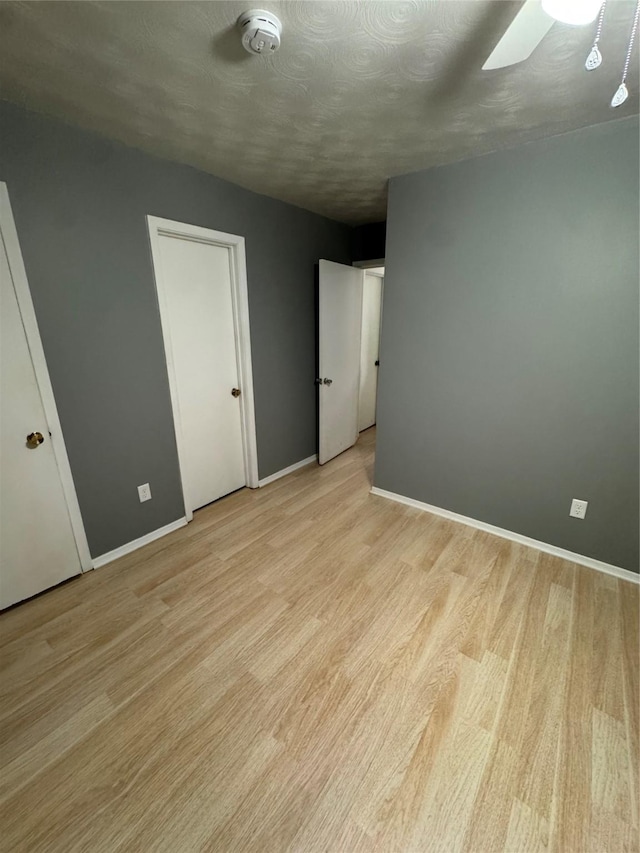 unfurnished bedroom featuring a textured ceiling and light wood-type flooring