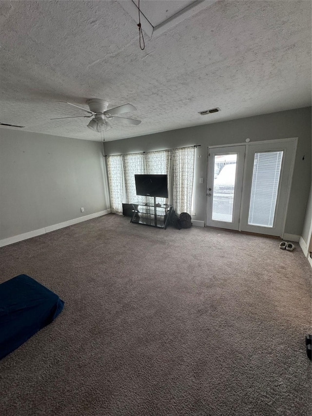 unfurnished living room with carpet flooring and a textured ceiling