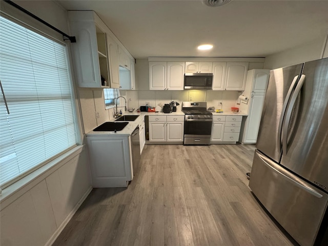 kitchen with white cabinetry, sink, light hardwood / wood-style flooring, and stainless steel appliances