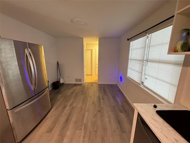 kitchen with sink, hardwood / wood-style floors, and stainless steel refrigerator