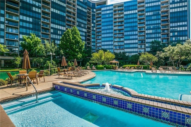 view of swimming pool featuring pool water feature and a patio