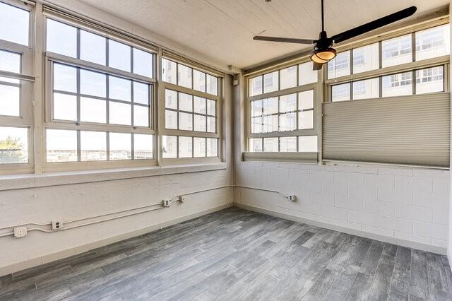 unfurnished sunroom with ceiling fan and wooden ceiling