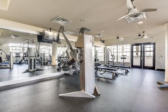 gym with a wealth of natural light and ceiling fan