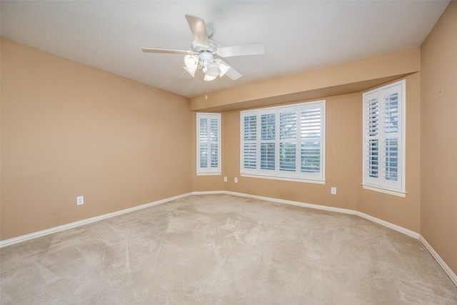 unfurnished room with light colored carpet, ceiling fan, and baseboards